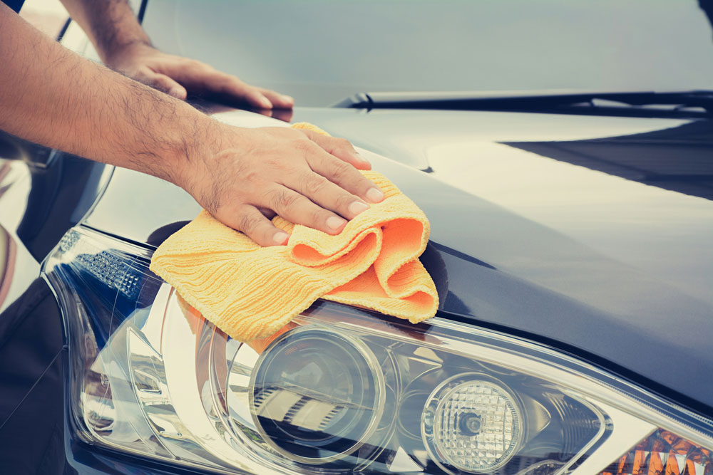A man cleaning car with microfiber cloth A man cleaning car with microfiber cloth
