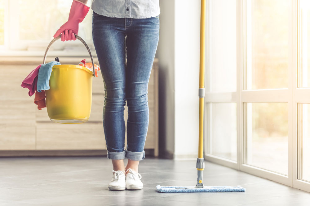 Cropped image of beautiful woman in protective gloves holding a flat wet-mop